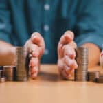 Hands separate coins on table