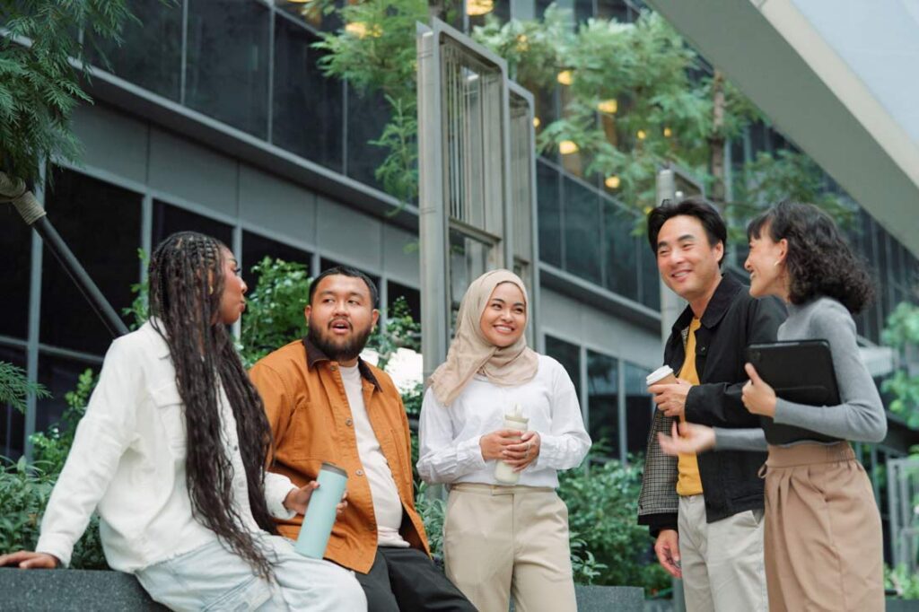 A group of diverse professionals talking outside a building
