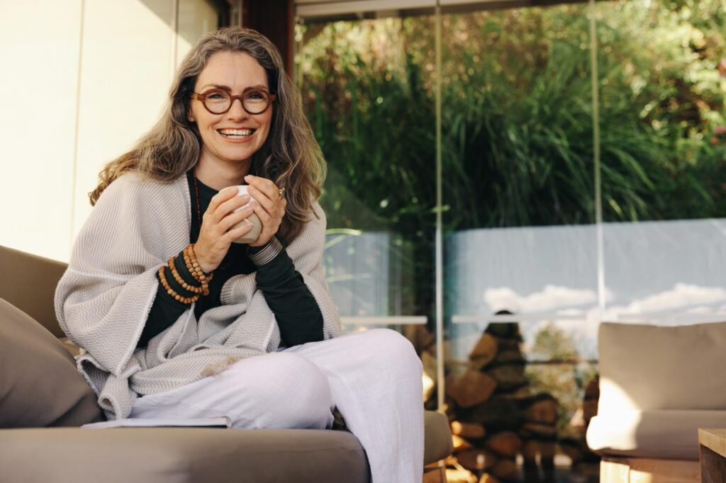 Middle aged woman in a beautiful location retirement planning for women and holding a cup of coffee