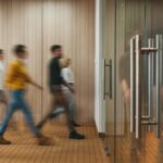 A timelapse photo of people entering and exiting a sleek office.