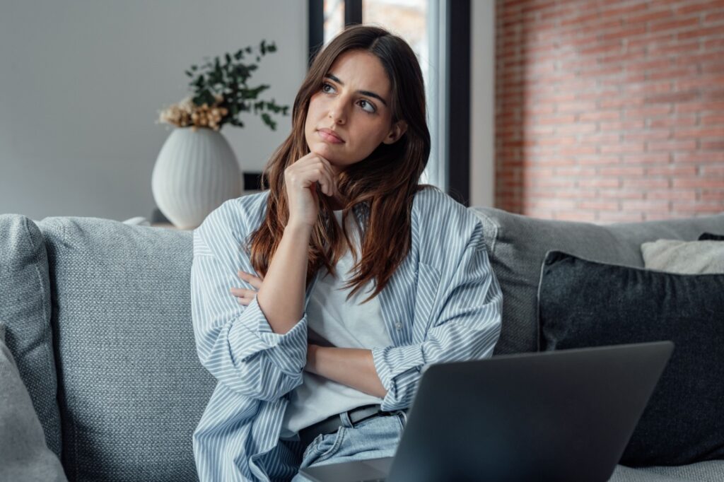A woman thinking on a couch.